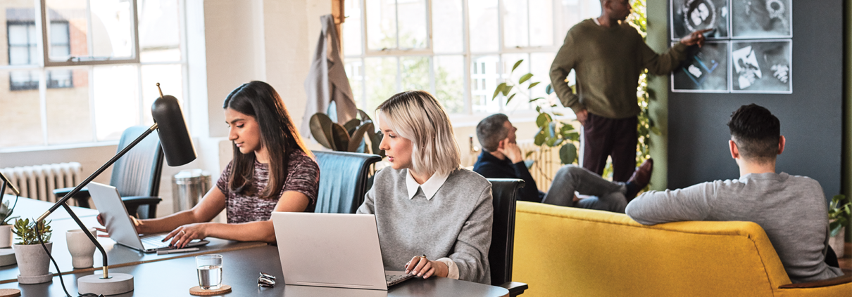 Twee collega's met een laptop werken samen met Microsoft Modern Workplace