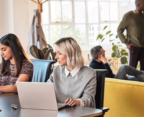 Twee collega's met een laptop werken samen met Microsoft Modern Workplace